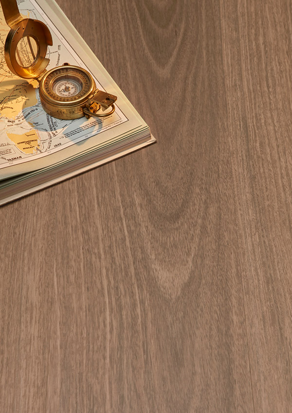 Hybrid Vinyl Flooring in colour 'Spotted Gum' with an atlas and gold compass placed on the floor.
